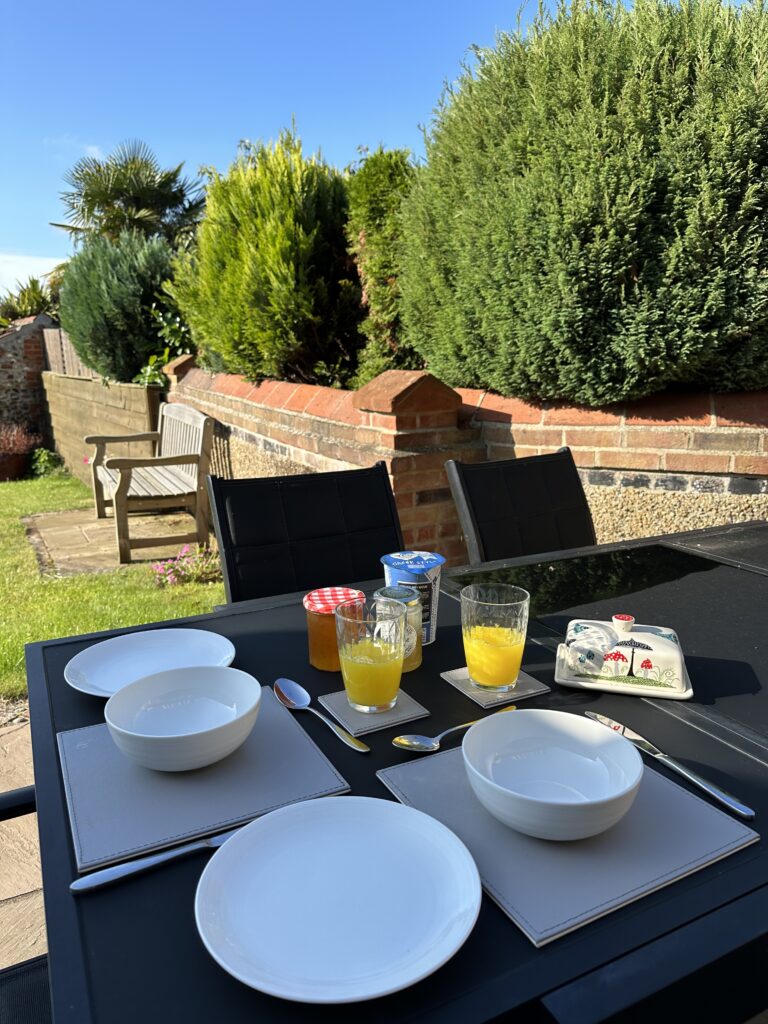 Photo shows a table outside set for breakfast. 