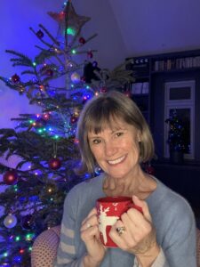 Image shows author Imogen Clark holding a mug in front of a Christmas tree.