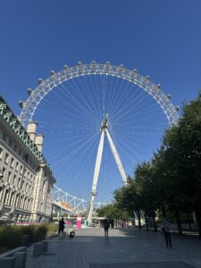 Image shows the London Eye with a bright blue sky 