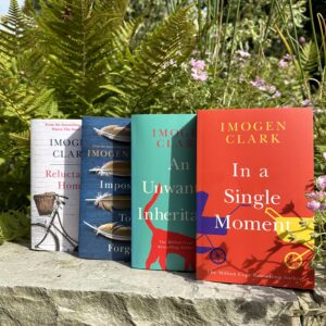 Image shows four of Imogen Clark’s books on a garden wall. 